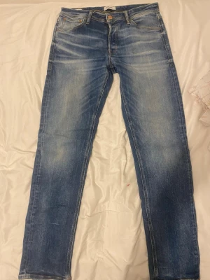 Blå slim fit jeans - Snygga blå slim fit jeans med ljusa slitningar och klassisk femficksdesign. Jeansen har normal midja, dragkedjegylf och kontrastsömmar. Materialet är denim i bomull med lite stretch för extra komfort. Perfekta för en avslappnad och trendig look. Priset går att diskutera 😁