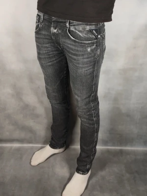 Grå slim fit jeans med slitningar - Snygga grå slim fit jeans med diskreta slitningar och tvättade detaljer. Jeansen har fem fickor, normal midja och smal passform hela vägen ner. Materialet är klassisk denim med stretch för extra komfort. Perfekta för en trendig och avslappnad stil.