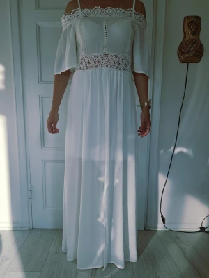 Mery & Street vit maxiklänning st S - Superfin vit långklänning med offshoulder och axelband. Klänningen har vackra spetsdetaljer upptill och i midjan samt vida trekvartsärmar. Perfekt för sommarens alla tillfällen och ger en romantisk vibe.Vit maxiklänning med bara axlar och spetsdetaljer. Klänningen har tunna axelband som faller elegant över armarna. Midjan markeras med ett brett spetsparti som ger en fin silhuett. Kjoldelen är lång och flödande, vilket skapar en elegant och luftig känsla.Den här Boohoo-maxiklännin