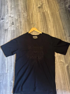 Svart Kenzo t-shirt  - Jätte fin svart kenzo T-shirt i storlek M, med jätte fin passform. Säljer på grund av att jag har en Annan liknande. 