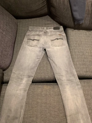 Grå slim fit jeans med bakfickor - Säljer ett par grå slim fit jeans med klassiska fyra fickor och snygga vågdetaljer på bakfickorna. Jeansen har normal midja och raka ben. Perfekta för dig som gillar en stilren och avslappnad look. Storlek w31 L32. Hör av dig vid frågor och priset är diskuterbart!