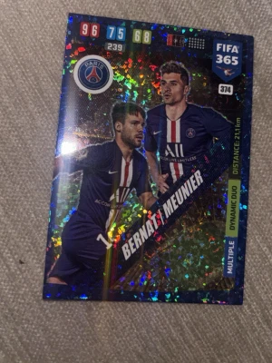 FIFA 365 Panini samlarkort PSG - Säljer ett glittrigt samlarkort från Panini FIFA 365-serien med spelarna Bernat och Meunier från PSG. Kortet har färgstarka detaljer, klubbmärke och statistik. Perfekt för dig som gillar fotboll och samlar på unika kort.