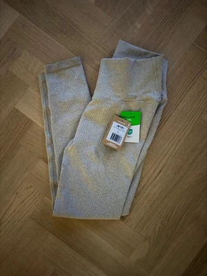 Aimn beige ribbade tränings leggings med hög midja - Snygga beige leggings med ribbad struktur och hög midja. De har en smickrande passform och är tillverkade i ett mjukt, stretchigt material som känns bekvämt hela dagen. Perfekta att matcha med en oversized hoodie eller crop top.