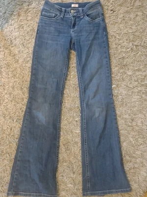 Blåa Nelly jeans  - Säljer ett par jättefina ljusblå bootcut jeans från Nelly med klassisk femficksmodell och snygga broderade detaljer på bakfickorna. Jeansen har normal midja och är tillverkade i ett mjukt denimtyg som ger en avslappnad look. Det är mina bilder och jag e 168 cm. Säljer för att de inte riktigt e min stil. 