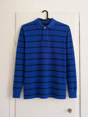 Polo Ralph Lauren långärmad randig piké – blå - Snygg långärmad piké från Polo Ralph Lauren i blått med mörkblå ränder. Klassisk krage, knappslå och liten broderad Ralph Lauren-logga på bröstet. Väldigt fin modell som passar bra till både jeans och chinos. Storlek: M (10-12) Skick: Bra,en den är lite missfärgad! Kan skicka mått eller fler bilder vid intresse 📦