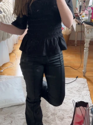 Svarta utsvängda jeans strl 32 - Säljer ett par svarta jeans/skinnbyxor ifrån nelly med låg midja. köpta för 699, men säljer för 150. I storlek 32