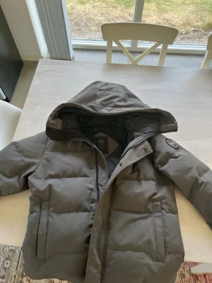 Canada goose black label puffer jacka - Pris kan absolut diskuteras eftersom jag behöver pengar fort så kan jag gå ner en del i pris!Säljer en mörkgrå pufferjacka med stor huva och dragkedja framtill. Jackan har två sidofickor och en patch på ärmen. Perfekt för kalla vinterdagar och har en stilren, enkel design som passar till det mesta.