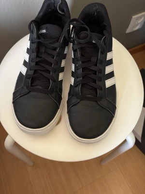 Svarta Adidas sneakers med vita ränder - .