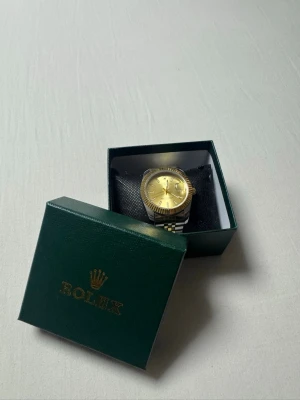 Rolle - snygg Rolle klocka i guld och silver färgat metall. Snygg klocka som passar till allt! Perfekt för dig som gillar att sticka ut.