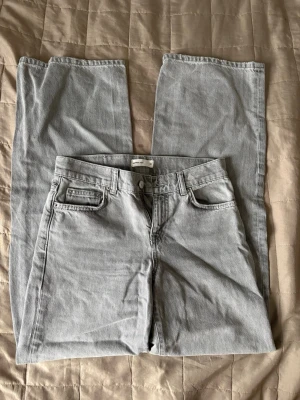 Grå raka jeans med hög midja - Snygga grå jeans med raka ben och hög midja. Klassisk femficksmodell med bälteshällor och dragkedjegylf. Jeansen är i ett mjukt denimtyg som passar perfekt till en avslappnad stil. Lite tightare uppe vid rumpan sen blir dom wide nere i benen