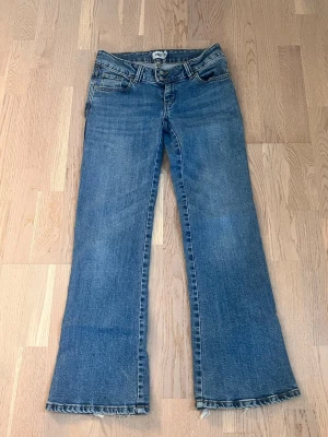 Low bootcut jeans  - Ett par klassiska blå bootcut jeans. Jeansen har fem fickor, låg midja och dragkedja med knapp. Tillverkade i denim med en snygg tvättad.