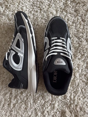 Svarta och vita sneakers B30 - Säljer ett par svarta och vita B30 sneakers. Dem är helt nya och aldrig använda, fantastisk kvalité! Storleken är 45 men passar både 45 och 44! Pris kan diskuteras!