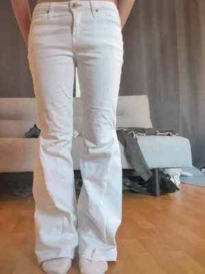 Lågmidjade vita jeans - Säljer dessa snygga vita jeans från Lee. De är omsydda till bootcut. Inga defekter men jag har sprättat upp de längst ner så att jeansen skulle bli längre. Midjemått 37 Innerbenslängden ca 74