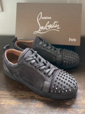 Gråa Christian Louboutin sneakers - Halloj! Nu säljer jag ett par riktigt fina skor från Christian Louboutin. Skorna är i mycket bra skick, det syns att dem är använda lite grann på undersidan, vilket det blir väldigt snabbt om man använder dem. Det finns både kvitto och låda till skorna såklart. Om det finns några frågor är det bara att dm’a mig! Pris kan också diskuteras, mvh. 