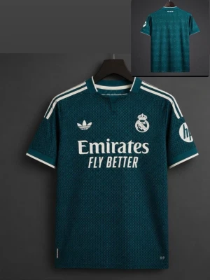 Real Madrid mörkgrön matchtröja - Snygg mörkgrön Real Madrid matchtröja från Adidas med vita detaljer och klubbmärke på bröstet. Tröjan har korta ärmar, rund hals och klassiska Adidas-ränder på axlarna. Tillverkad i lätt och ventilerande material, perfekt för fotboll eller träning.