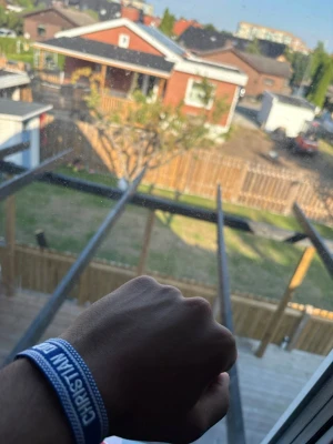 Blått Christian Dior J'Adior armband - Säljer ett blått tygarmband från Christian Dior med texten 'J'Adior' i vitt. Armbandet har en enkel, avslappnad design med fransar i ändarna och är perfekt för dig som vill ha en cool accessoar med lyxig känsla.