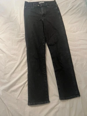 Svarta mom fit jeans straight - Säljer ett par svarta mom fit jeans med rak passform. Jeansen har klassisk femficksdesign och hög midja. 