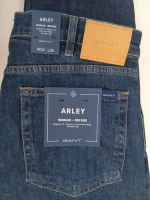 GANT Herr jeans - Snygga herr jeans från GANT, modell Arley. Dom är helt nya med tags/prislapp kvar! Jeansen har raka ben och en regular fit med medelhög midja som ger en modern stil. Detaljerna omfattar en femficksdesign, nitar och knappar med logo, gylf med dragkedja samt en läderetikett bak på linningen. Den här modellen är normal i storleken w34 L32. Nypris 1500 kr