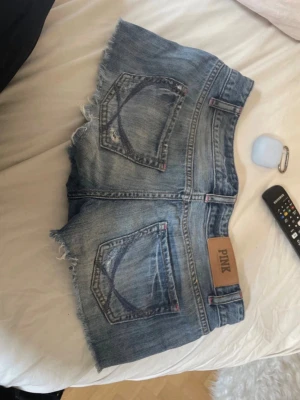 Blå jeansshorts från PINK - Säljer ett par blå jeansshorts från PINK med  slitna detaljer passar perfekt för sommaren och festivaler! De är st Xs men passar även S. 