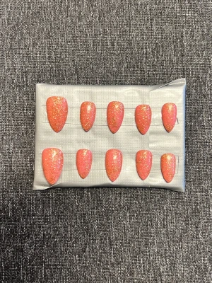 Rosa press-on naglar med glitter || Storlek S - Ett set med press-on naglar i en snygg rosa nyans med guldigt glitter I storlek S. Naglarna har mandelform och är gjorda i plast. Perfekt för dig som vill ha en trendig och glittrig look på nolltid. Det du får med dig : * Fil och manikyr pinne * nagellim klistermärken * 2 lappar av rengöring för naglar.