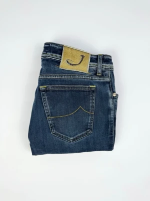 Jacob Cohën jeans  - Mörkblå jacob Cohën jeans Märke: Jacob Cohën Storlek: Size 34, sitter mindre Passform: Slimfit Färg: Mörkblå Skick: Okej, har små fläckar och vissa slitningar. Mått: Midja: 42 cm Längd: 90 cm Öppning vid fot: 15 cm 