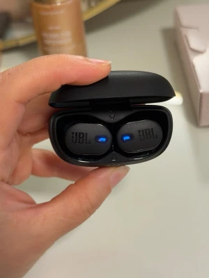JBL Tune Buds 2 svarta in-ear hörlurar - Säljer ett par svarta JBL Tune Buds 2 true wireless in-ear hörlurar med laddningsetui. Snygg och kompakt design med diskreta blå LED-lampor som visar laddningsstatus. Perfekta för musik, poddar och samtal på språng. Som nya, använt ca 3 gånger 