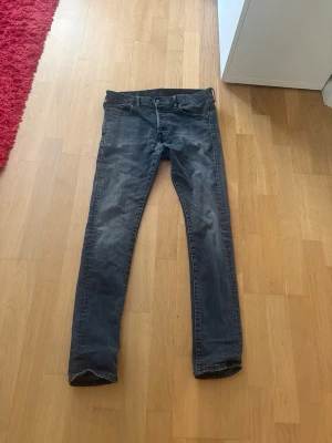 Mörkgrå slim fit jeans - Snygga mörkgrå slim fit jeans med klassisk femficksdesign och normal midja. Jeansen har en lätt tvättad look och raka ben. Perfekta för en avslappnad och trendig stil.