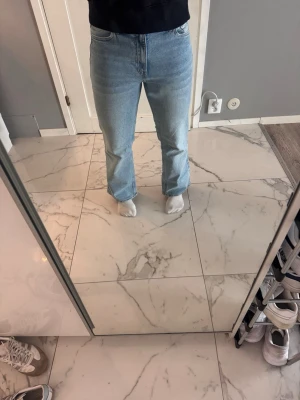 Blåa Bootcut jeans från hm - Säljer ett par ljusblå jeans från hm då de inte längre används. Modellen är något kortare i benen, längden ses på bild. Bra skick och inga tecken på användning. Meddela vid frågor:)
