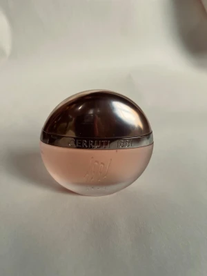 Cerruti 1881, 100ml - Unik parfymflaska från Cerruti 1881 i rund, oval form. Flaskan är frostad i ljusrosa glas med en metallisk, roséguldig topp. Elegant design som sticker ut på hyllan och passar perfekt för dig som gillar exklusiva dofter och snygga detaljer. Bara testad, inte min kopp te.