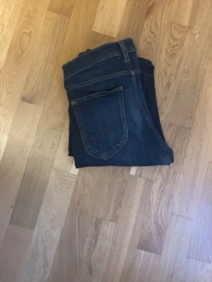 Lee jeans - Ett par mörkblåa jeans från lee i modellen Luke. Jeansen sitter som ett par slimfit jeans och är i ett mycket bra skick därav de har bara använts ett fåtal gånger. Pris kan diskuteras.
