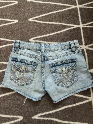 Ljusblå jeansshorts med paljettdetalj - Säljer Gina Young-jeansshorts i minimodell med låg midja. Storlek 158, motsvarar XS. Fina fickor. Toppskick! 🤍 #lowwaist #minishorts #jeansshorts #lågmidja #2000tal #y2k #stockholmstil #stockholmstyle 🌟