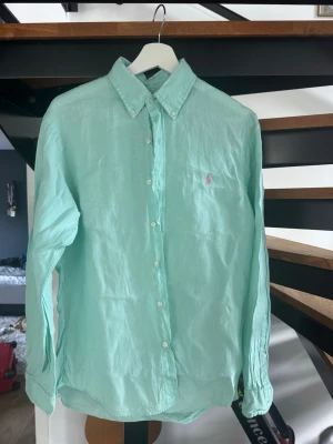 Ralph Lauren Linneskjorta - Mintgrön Ralph Lauren linneskjorta i strl M, slim fit. Väldigt bra skick då den är använd sparsamt. Perfekt nu på sensommaren eller början på hösten!