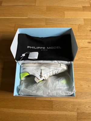  Philippe Model sneakers - Ett par feta vita sneakers från Philippe Model med detaljer i neon-gult på hälen. Skorna är i mycket gott skick, 8,5/10 Allt OG ingår dvs Låda, Dustbag, och lappar.                           Nypris 320€/3500kr. Storlek 43, passar även 44. Pris kan diskuteras! 