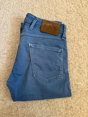 Replay Anbass Slim Fit Jeans – W30/L32 - Replay Anbass Slim Fit jeans i snygg blå tvätt. En populär premiummodell med stretch som sitter riktigt bra och passar både sneakers och skjorta. Använda men i mycket fint skick utan anmärkningar.  • Märke: Replay • Modell: Anbass Slim Fit • Storlek: W30 L32 • Mycket bra skick  📦 Skickas snabbt!