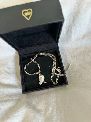 Maria Nilsdotter halsband - Säljer ett halsband från Maria Nilsdotter i längd 40. Nypris är 3595 kr för båda halvorna, men jag säljer endast ena halvan med kedjan. Äkta silver. Ingen färg är avskavd utan det är ljuset som kan få det att se ut så. Kontakta mig för frågor!☺️