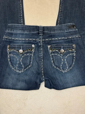Mörkblå jeans med detaljerade fickor - Ett par skit snygga bootcut jeans från Amor, trust & truth. Dessa har snygga detaljer på fickorna och är i super fint skick! Mått kan alltid skickas privat!💕