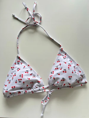 Cherry bikini topp - En vit bikinitopp med körbärs-mönster. Storlek M. Blev aldrig använd. Nyskick!