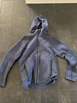 Blå hoodie från Nike med dragkedja - Blå Nike tech hoodie använd några gånger men i ny skick 