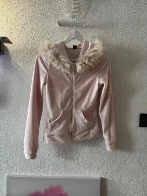 Ljusrosa hoodie med fuskpäls - Söt ljusrosa hoodie med dragkedja framtill och stor huva kantad med fluffig fuskpäls. Hoodien har två fickor fram och är gjord i ett mjukt material som känns skönt mot huden. Perfekt för dig som gillar mysiga och trendiga plagg. Köpt här på plick för 350 sek! Knappt använd🫶🏻Vet tyvärr inte vart den är ifrån eftersom att den förra ägaren hade rivit av lappen😊🤍🫶🏻