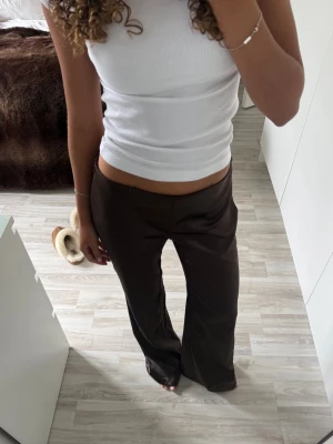 Bruna kostymbyxor med låg midja -  Bruna Satin liknande byxor, låga i midjan skulle säga att de sitter som en s