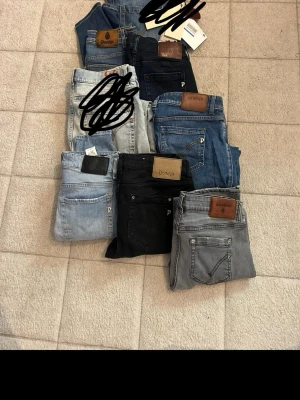 Flera par jeans i olika färger - Säljer ett gäng jeans i olika tvättar och färger, bland annat ljusblå, svart, grå och klassisk blå denim. Några har läderpatch med Dunlop-logga. Modellerna varierar mellan raka och smalare ben. Perfekt för dig som vill ha flera stilar att välja mellan.6 par