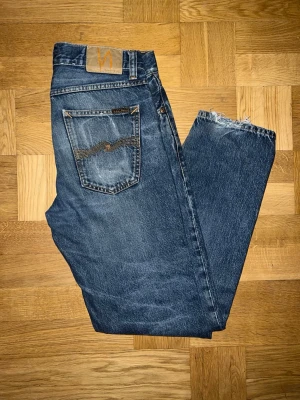 Blå raka jeans från Nudie Jeans - Säljer dessa feta Nudie Jeans då dom blivit för små. Modell Gritty Jacksson och mått finns i bilderna, passar mer som W31. Dessa jeans har vart med om mycket genom åren. Skicka gärna DM vid funderingar!