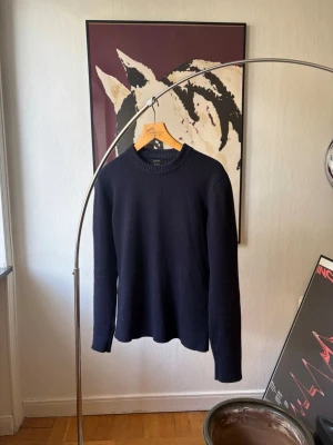 Massimo Dutti Knit - Klassisk mörkblå stickad tröja med rund hals och ribbade muddar. Tröjan är gjord i mjuk ull och har en enkel, stilren design som passar till det mesta. Perfekt för lager på lager och håller dig varm under kyliga dagar.