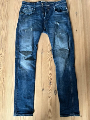 Replay jeans - Snygga mörkblå replay jeans med slitningar. Anbass slim fit modell. Storlek 31 W och 32 L. 