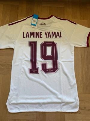Lamine Yamal #19 – Spanien Borta (storlek M) - Lamine Yamal #19-tryck. Spanien Borta. Storlek M. Helt ny och aldrig använd. Skickas snabbt 🚚💨  Mått (M): Halvt bröstmått 51 cm • Längd 72,5 cm • Ärmbredd 22,5 cm • Axelbredd 43 cm • Ärmlängd 39 cm • Manschett 18 cm.  🔥 Player Edition – tajtare passform än vanliga supportertröjor. 🇪🇸 Spanien landslag. Vm vinnande lag! 