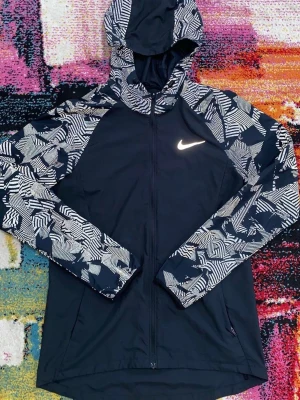 Nike miller windbreaker  - Nike Reflective Jacket  Sällsynt Nike-jacka i nytt skick med riktigt snygga reflektiva detaljer som ger ett exklusivt uttryck när ljus träffar materialet. En modell som är svår att hitta och perfekt för dig som vill ha en mer unik Nike-look.  • Nike • Reflektiv design • Sällsynt modell • Nytt skick • Storlek: S • Stilren och sportig passform  Mycket fin jacka som gör sig riktigt bra både till vardags och för en sportigare outfit.  Skickas snabbt och välpackat. Inga orimliga bud.