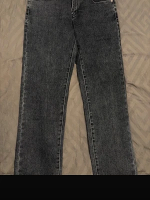 Mörkblå jeans - Säljer ett par mörkblå jeans med rak passform och klassisk femficksdesign. Jeansen har en enkel look utan slitningar och är tillverkade i denim. Perfekta för dig som gillar en tidlös och clean stil.