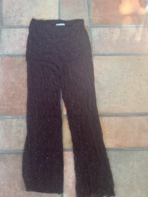 Bruna spetsleggings med pärlor Pull&Bear - Säljer ett par super fina bruna/vinröda leggings från Pull&Bear i storlek XS. De är gjorda i spetsmaterial och dekorerade med små pärlor över hela tyget. Säljer pgr av att jag inte använder dem. De är alldrig använda endast provade hemma och därför är lappen borta🩷