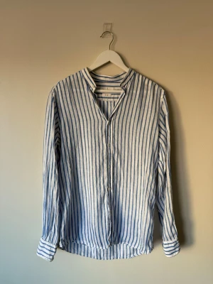 Linneskjorta från Massimo Dutti - Säljer en stilren skjorta i blåvitt randigt mönster från Massimo Dutti. 100% linne.