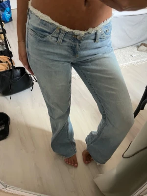 Ljusblå bootcut jeans från Nelly - Säljer ett par ljusblå bootcut jeans ifrån Nelly. Jeansen har klassisk femficksdesign och är tillverkade i denim med lätt tvättad look. Perfekta för dig som gillar en avslappnad och trendig stil. De är avklippta för att passa någon som är 160-165 mc lång